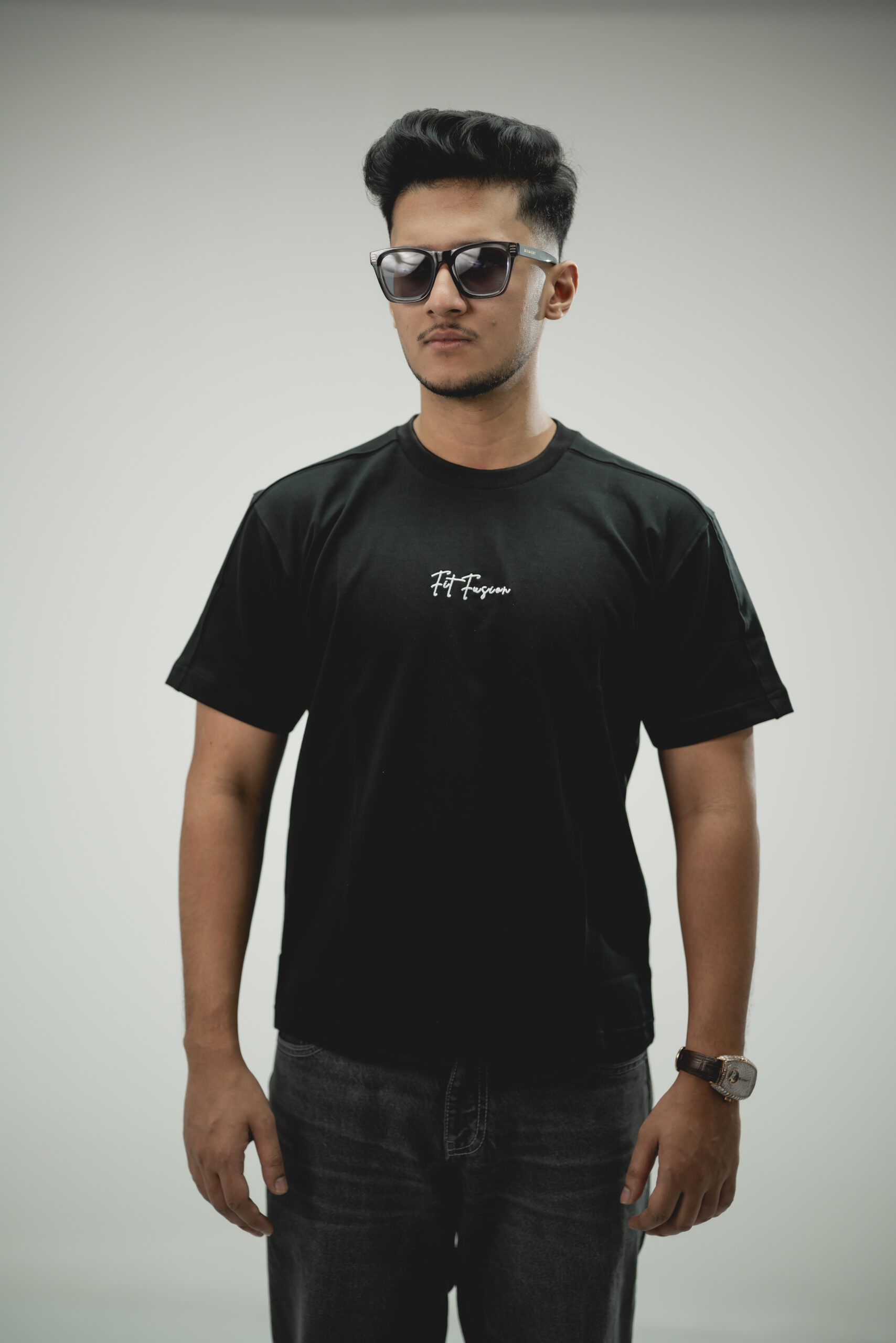 Man wearing black terry fabric drop shoulder t-Shirt with round neck, styled with dark denim jeans